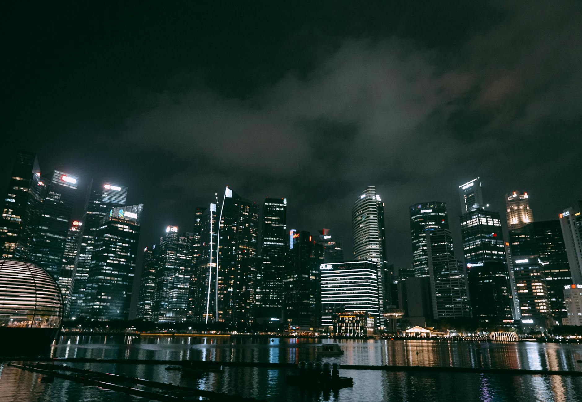 A stunning view of Singapore's skyline at night with illuminated skyscrapers and reflections.